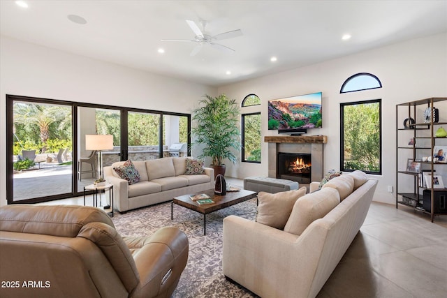 living room with ceiling fan, recessed lighting, a warm lit fireplace, and a healthy amount of sunlight