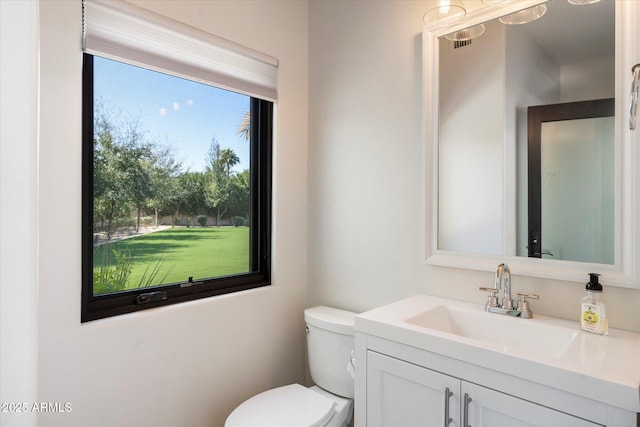 half bathroom featuring vanity, toilet, and visible vents