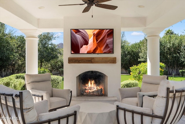 view of patio / terrace with ceiling fan and a lit fireplace