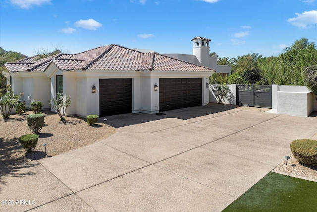 view of front of property with a gate, fence, stucco siding, concrete driveway, and a tiled roof