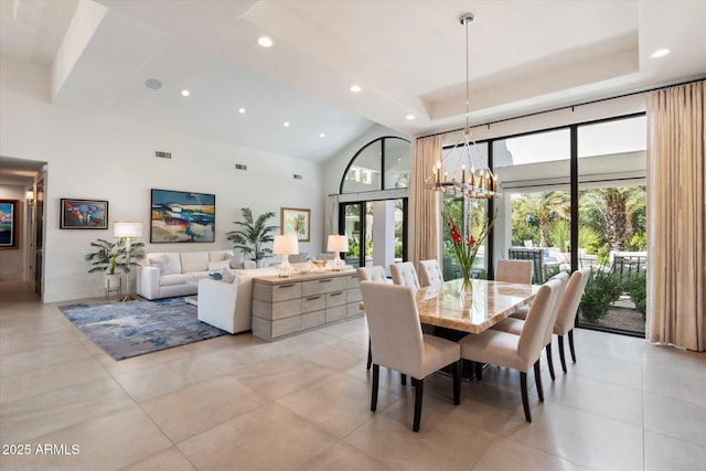 dining room with a wealth of natural light, a tray ceiling, and a high ceiling