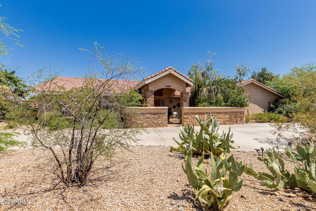 12837 N 68th St, Scottsdale, AZ 85254 - mediterranean / spanish-style home featuring a tiled roof, stucco siding, and stone siding