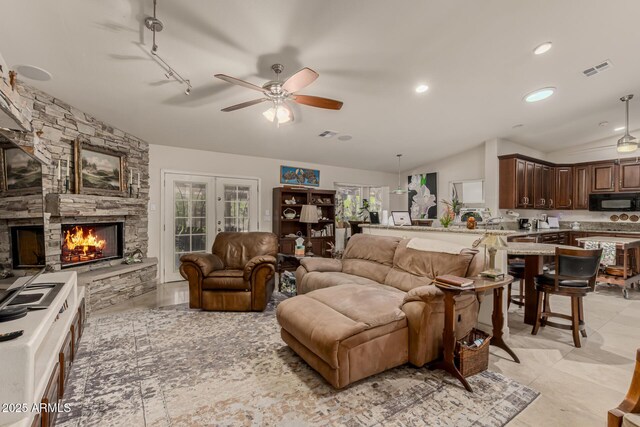 12837 N 68th St, Scottsdale, AZ 85254 - living area featuring lofted ceiling, a ceiling fan, a stone fireplace, recessed lighting, and track lighting