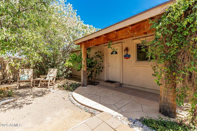 12837 N 68th St, Scottsdale, AZ 85254 - view of exterior entry featuring a patio area and stucco siding