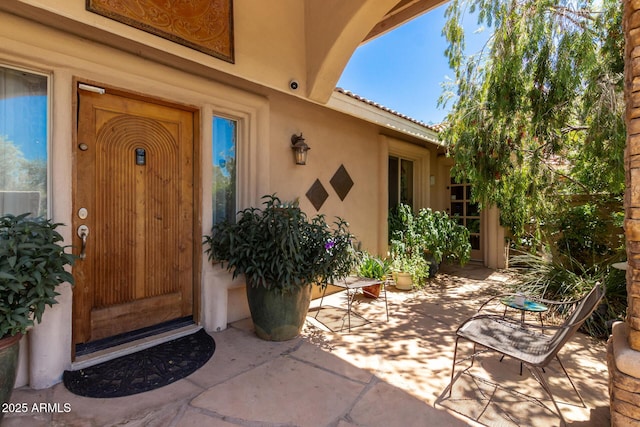 12837 N 68th St, Scottsdale, AZ 85254 - view of exterior entry featuring stucco siding and a patio area