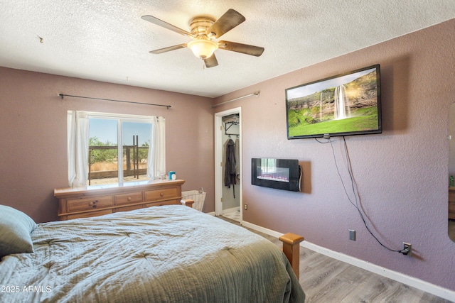 8730 E Barataria Blvd, Sierra Vista, AZ 85650 - bedroom featuring light wood-style flooring, a textured ceiling, baseboards, a ceiling fan, and a closet