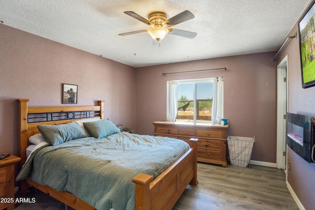 8730 E Barataria Blvd, Sierra Vista, AZ 85650 - bedroom featuring light wood-type flooring, a textured ceiling, ceiling fan, and baseboards