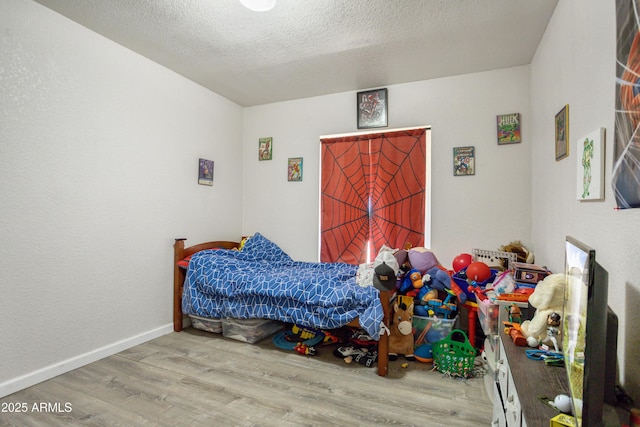 8730 E Barataria Blvd, Sierra Vista, AZ 85650 - bedroom featuring wood finished floors, a textured ceiling, and baseboards