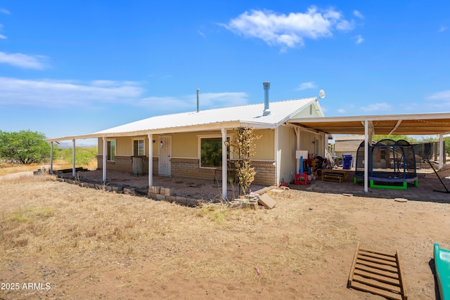 8730 E Barataria Blvd, Sierra Vista, AZ 85650 - back of property with brick siding, a trampoline, and metal roof