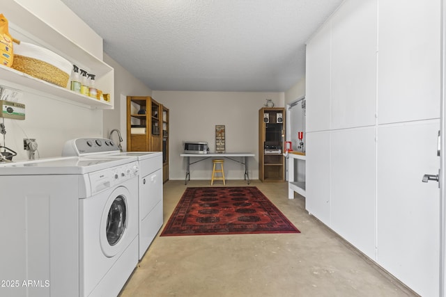 washroom with cabinets, washer and clothes dryer, and a textured ceiling