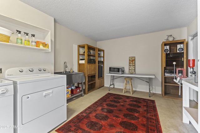 laundry area featuring sink, washer and clothes dryer, and a textured ceiling