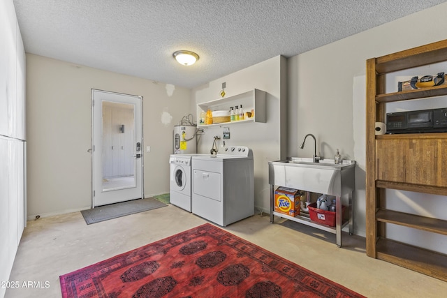 laundry room featuring independent washer and dryer, water heater, and a textured ceiling