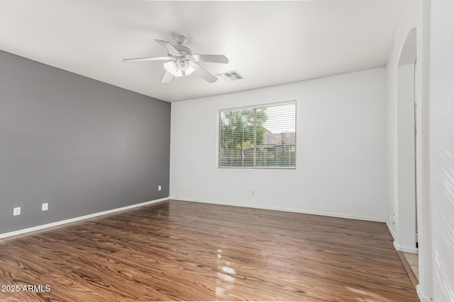 28232 N Abby Cir, San Tan Valley, AZ 85143 - empty room with arched walkways, wood finished floors, ceiling fan, and baseboards