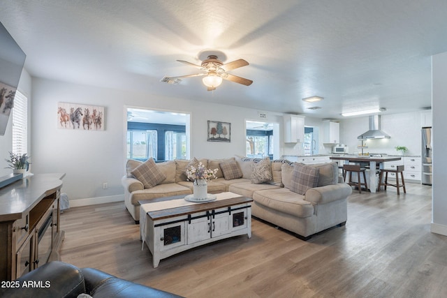 21188 N Duncan Dr, Maricopa, AZ 85138 - living area featuring a ceiling fan, light wood-style flooring, and baseboards