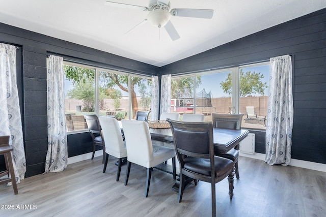 21188 N Duncan Dr, Maricopa, AZ 85138 - dining room with lofted ceiling, healthy amount of natural light, wood finished floors, a ceiling fan, and wooden walls