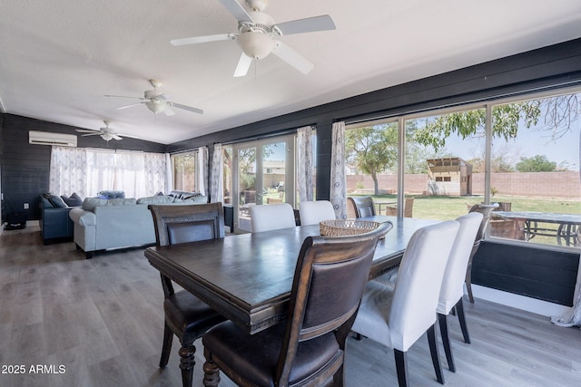21188 N Duncan Dr, Maricopa, AZ 85138 - dining space featuring wood finished floors, a wall unit AC, a ceiling fan, and lofted ceiling