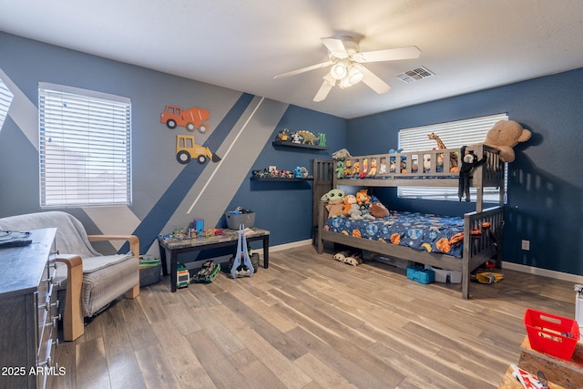 21188 N Duncan Dr, Maricopa, AZ 85138 - bedroom with wood finished floors, multiple windows, ceiling fan, and baseboards