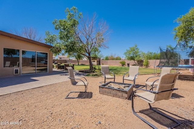 21188 N Duncan Dr, Maricopa, AZ 85138 - fenced yard with a trampoline, an outdoor fire pit, and a patio