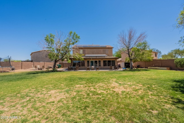21188 N Duncan Dr, Maricopa, AZ 85138 - back of property with a trampoline, a sunroom, a patio area, roof mounted solar panels, and stucco siding