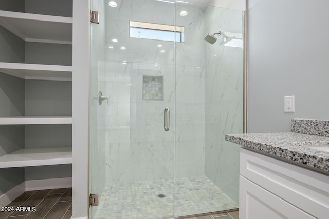 bathroom with vanity and a shower with door