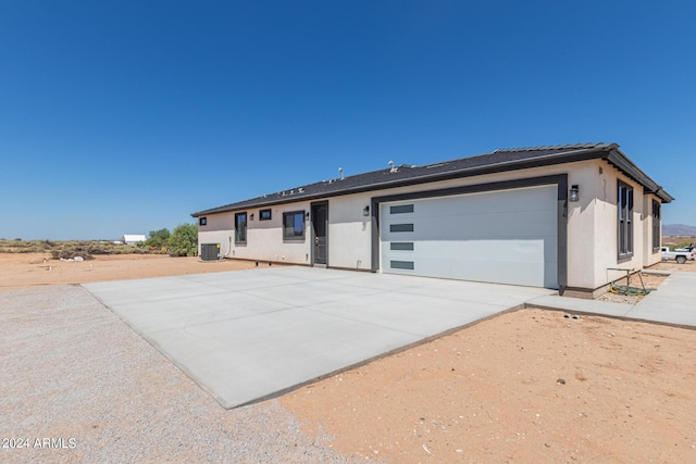 view of front of property with a garage and cooling unit