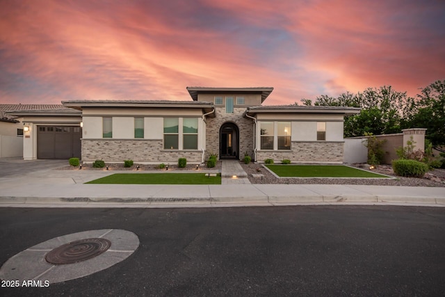 prairie-style house featuring driveway, an attached garage, a tiled roof, and stucco siding