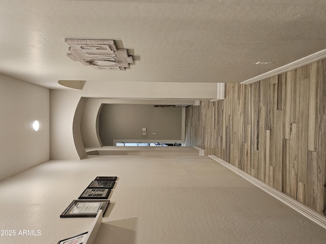 hallway with wooden walls and a textured ceiling