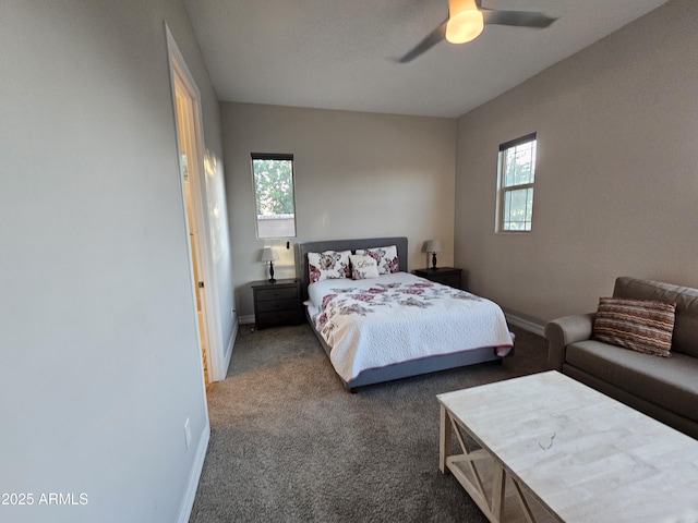 carpeted bedroom with ceiling fan, multiple windows, and baseboards