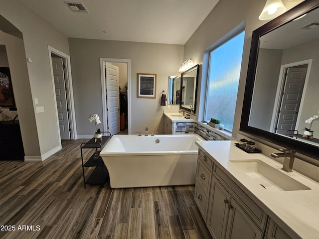 full bath featuring visible vents, a sink, and wood finished floors