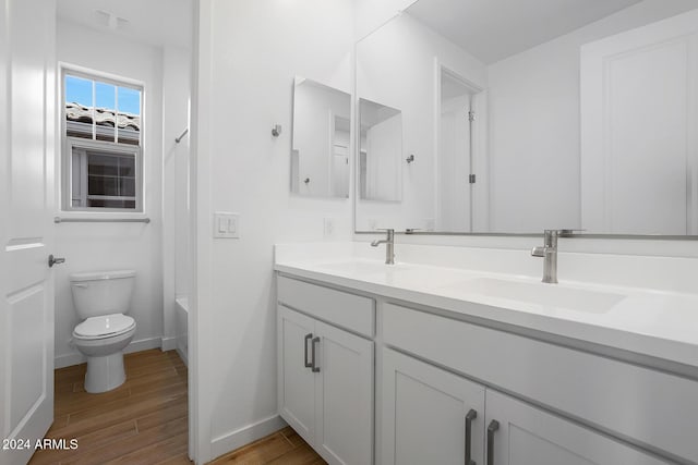 bathroom featuring wood-type flooring, vanity, and toilet