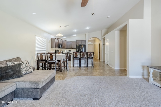 2717 W Bowker St, Phoenix, AZ 85041 - living room featuring arched walkways, ceiling fan, light carpet, and vaulted ceiling