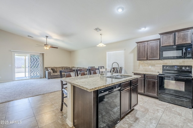 2717 W Bowker St, Phoenix, AZ 85041 - kitchen with black appliances, a breakfast bar area, lofted ceiling, dark brown cabinets, and open floor plan
