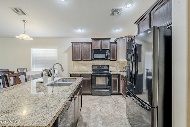 2717 W Bowker St, Phoenix, AZ 85041 - kitchen with black appliances, dark brown cabinets, backsplash, hanging light fixtures, and light stone counters