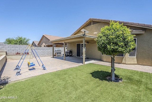 2717 W Bowker St, Phoenix, AZ 85041 - rear view of house with stucco siding, a fenced backyard, a playground, and a patio area