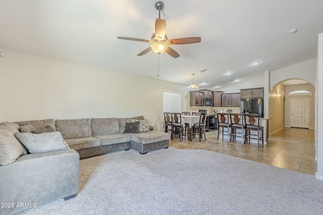 2717 W Bowker St, Phoenix, AZ 85041 - living room featuring arched walkways, ceiling fan, light colored carpet, lofted ceiling, and light tile patterned flooring