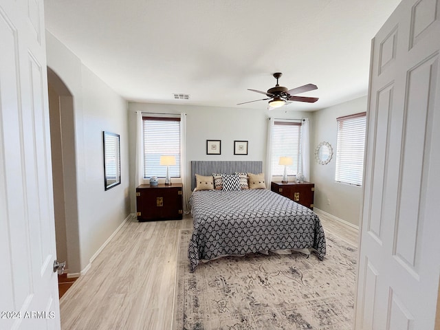 bedroom featuring light wood-type flooring, multiple windows, and ceiling fan