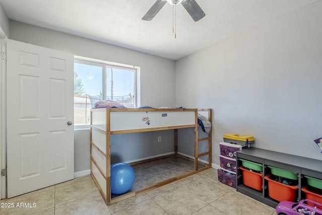 tiled bedroom featuring baseboards and ceiling fan