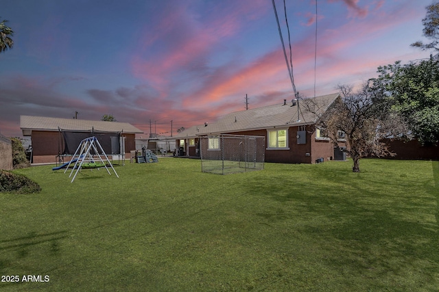 yard at dusk featuring a playground