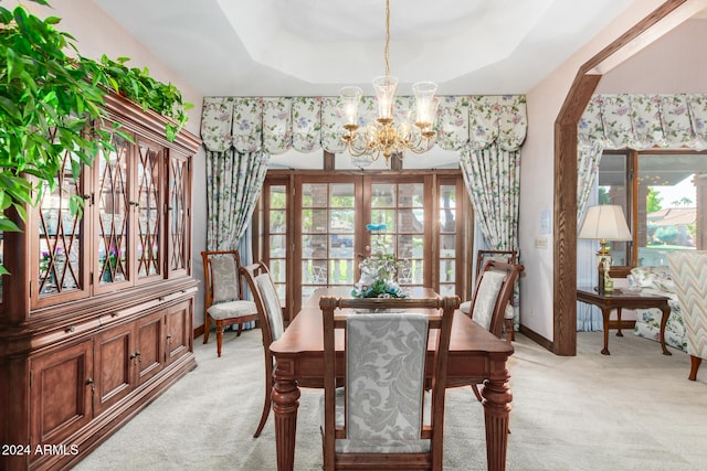 carpeted dining room featuring a chandelier