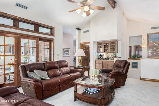 carpeted living room with high vaulted ceiling, beamed ceiling, and ceiling fan