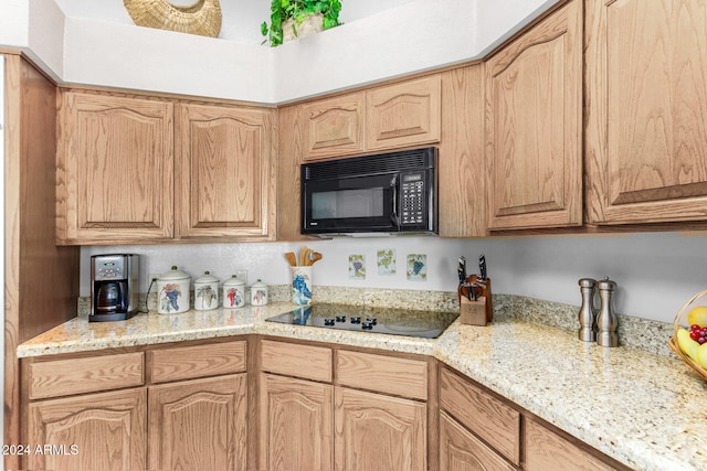 kitchen with black appliances and light stone counters