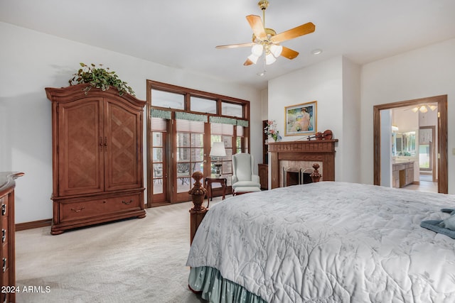 carpeted bedroom with a fireplace, ensuite bath, multiple windows, and ceiling fan