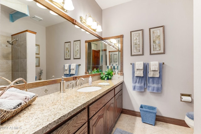 bathroom with vanity, tile patterned floors, toilet, and a tile shower