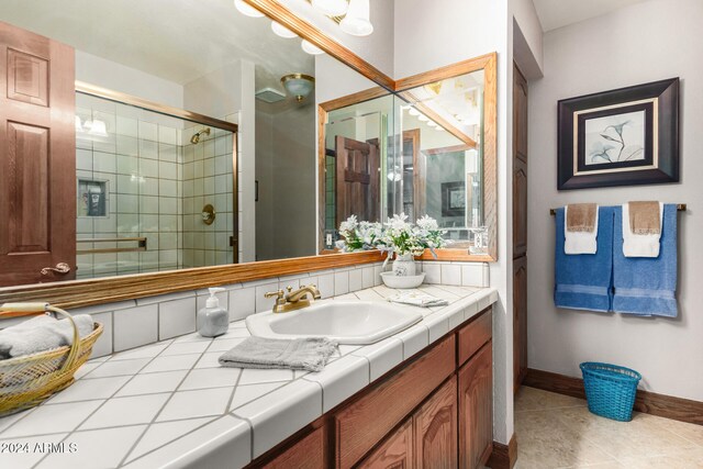 bathroom with walk in shower, tile patterned flooring, and vanity