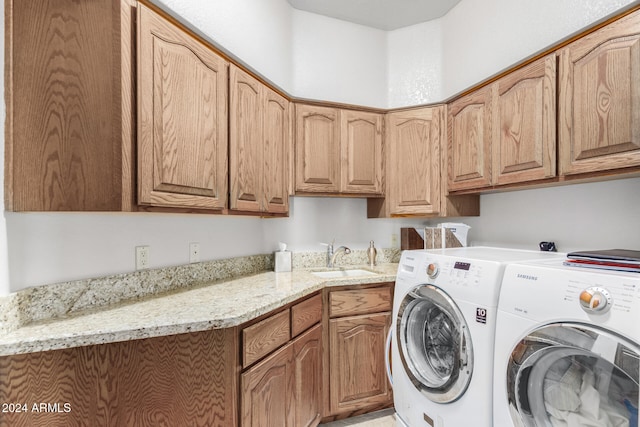 laundry room with cabinets, sink, and washer and clothes dryer