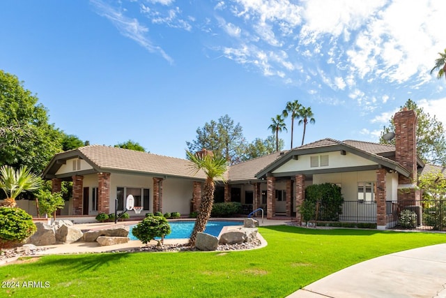 view of front of house with a fenced in pool and a front lawn