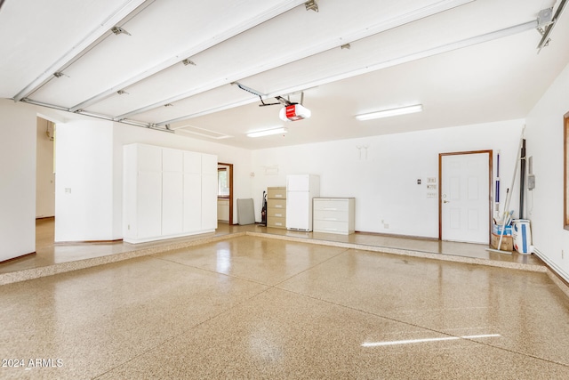 garage with white fridge and a garage door opener