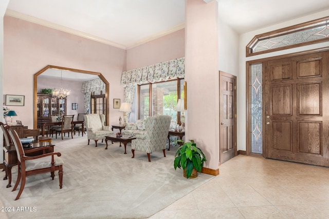 foyer entrance with light colored carpet, an inviting chandelier, and ornamental molding