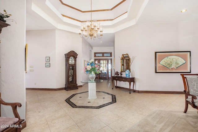 tiled entrance foyer with a chandelier and a tray ceiling