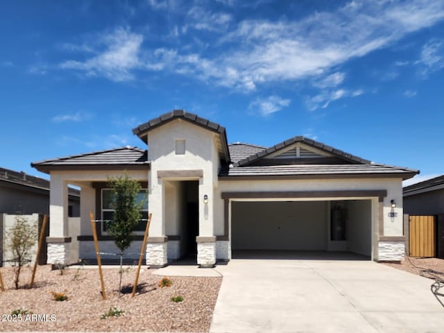 10524 W Bloch Rd, Tolleson, AZ 85353 - view of front of home with a garage, driveway, a tiled roof, stone siding, and stucco siding